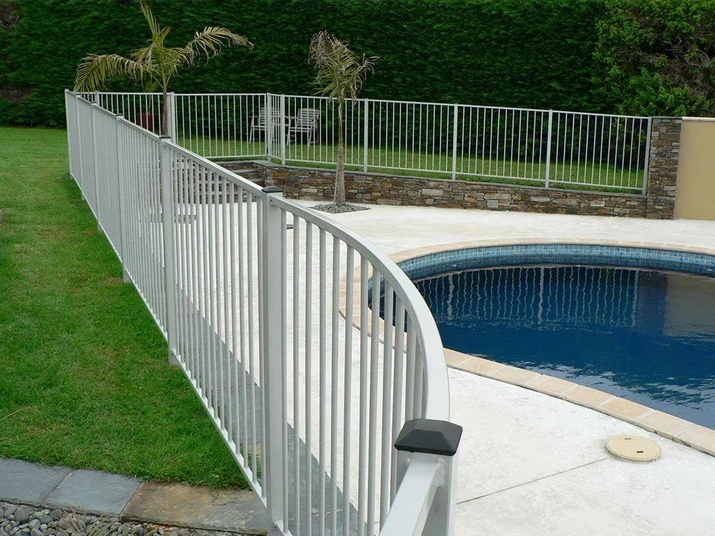 White aluminium pool fence with vertical bars around a residential swimming pool in the Bay of Plenty